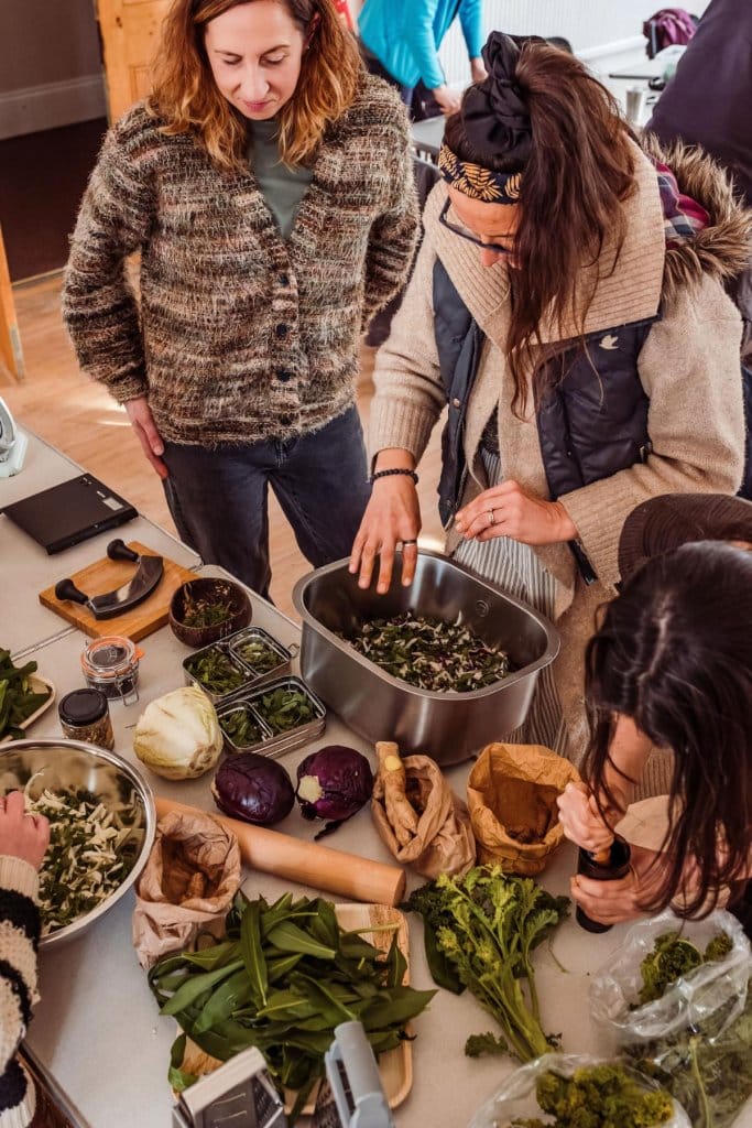 People chopping wild greens and vegetables around a table at a Forage & Ferment foraging masterclass